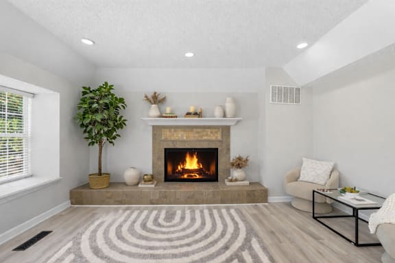 A living room with a fireplace and a tree.