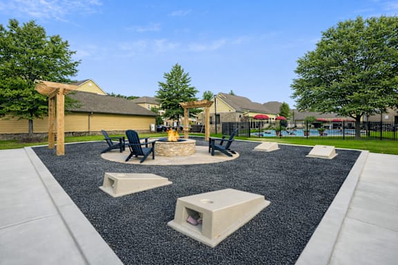 A playground with a black rubber surface and concrete structures.