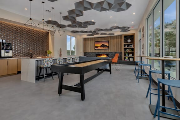 Community clubhouse with shuffleboard and fireplace at Prosper West Apartments, Waite Park, Minnesota