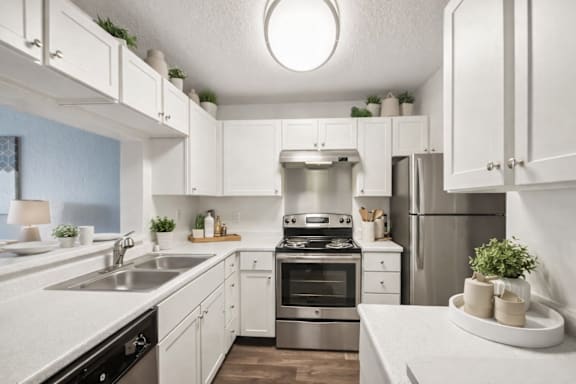A modern kitchen with white cabinets and stainless steel appliances.