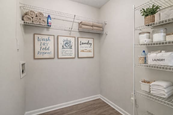 A laundry sign is on the wall above a shelf with towels.