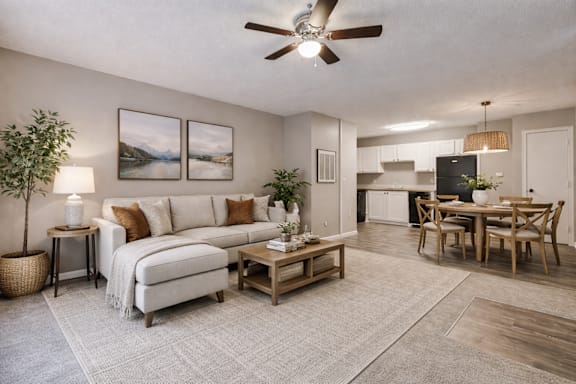 A living room with a couch, a coffee table, and a dining table.