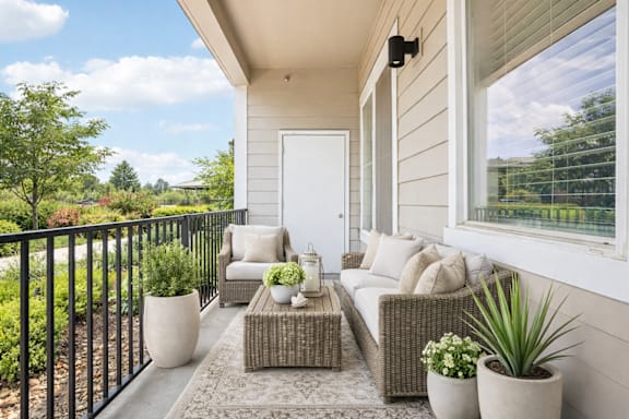Private balcony with cushioned seating and planters at Connect at First Creek Apartments, Denver, Colorado