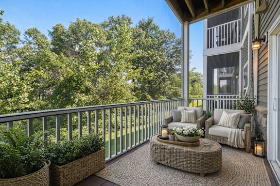 A balcony with a table and chairs and a view of a house.