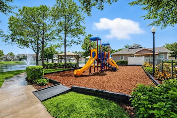 A playground with a yellow slide and a blue swing set. at Waterbridge Apartments , Florida, 32837