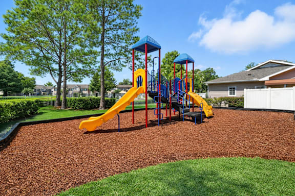 A playground with a yellow slide and a blue top. at Waterbridge Apartments , Orlando, 32837