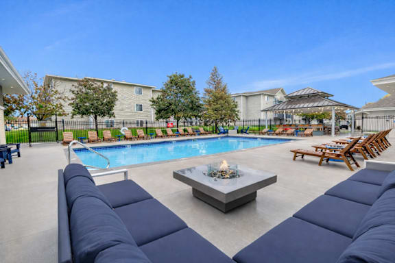 Pool area with fire pit and lounge seating at Prosper West Apartments, Minnesota, 56387