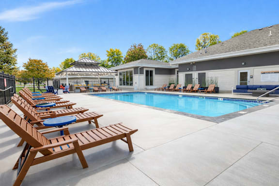 Resort style pool with lounge chairs and clubhouse at Prosper West Apartments, Waite Park, MN 56387