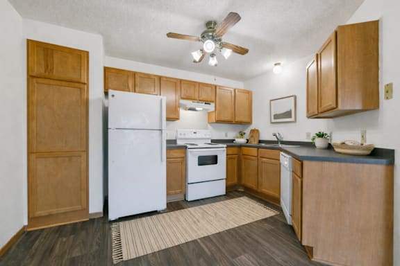 A kitchen with wooden cabinets and a white refrigerator.