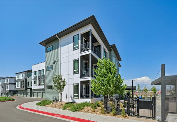 Modern three story apartment building exterior with balconies at Sequel Homes Apartments, Colorado, 80110