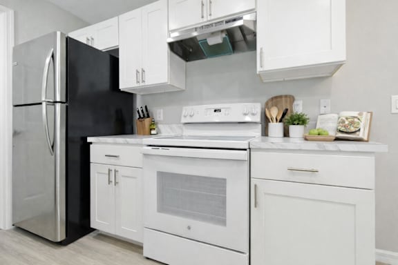 A modern kitchen with white appliances and cabinets.