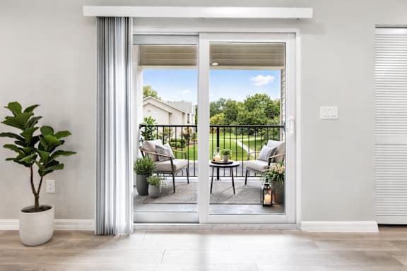 A patio with a table and chairs is visible through a sliding glass door.