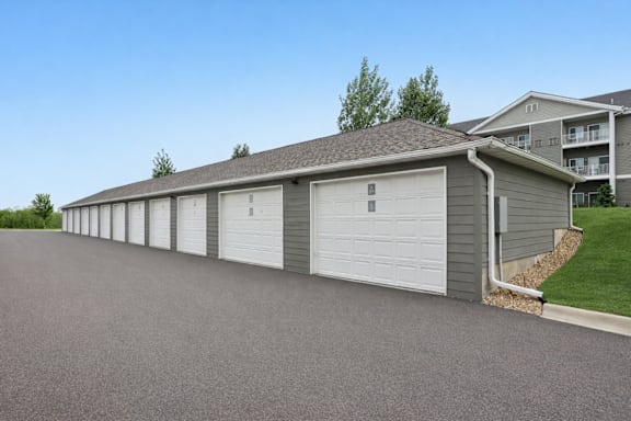 A long building with a grey roof and white garage doors.