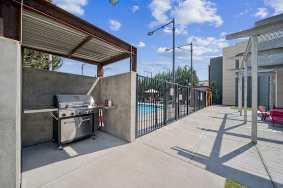 Covered bbq grill station with pool view at Lofts at Innovation Center Apartments, Richland