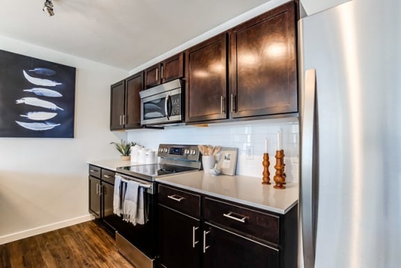 kitchen with dark cabinets and quartz countertops at Connect at First Creek, CO 80249