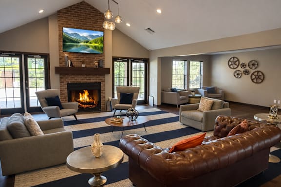 A living room with a fireplace and a television mounted above it.