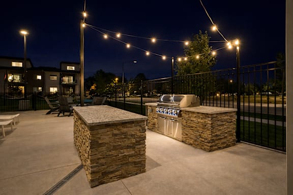 Outdoor kitchen with builtin grill and string lights at Harper Ridge Apartments, Meridian, Idaho