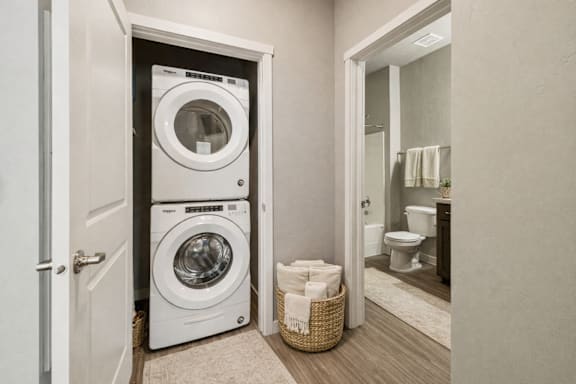 Stacked washer and dryer unit in hallway closet at Harper Ridge Apartments, Idaho