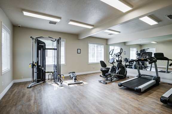 A spacious home gym with a variety of exercise equipment at Haven Pointe Apartments, Apartments, West Haven, UT