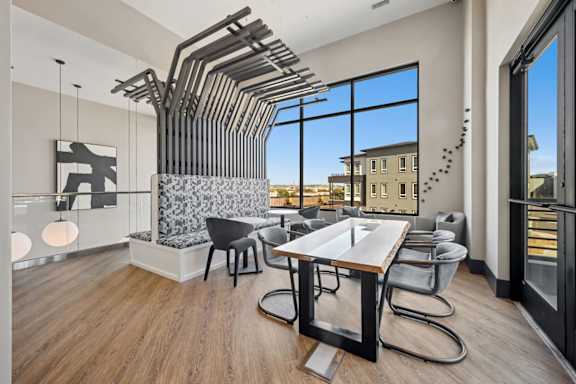 Dining area with modern table and sculptural ceiling installation at Sequel Homes Apartments, Colorado