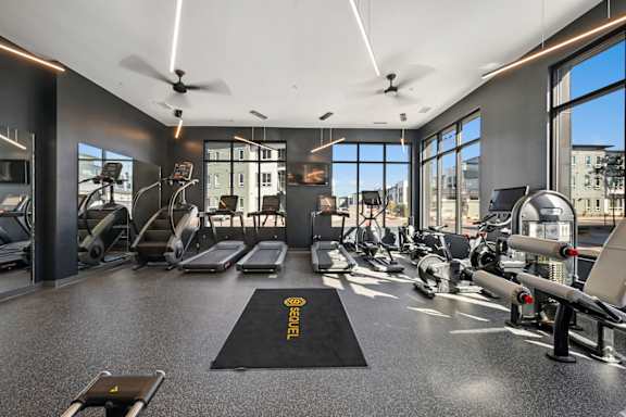 Fitness center with cardio equipment and large windows at Sequel Homes Apartments, Englewood, CO 80110