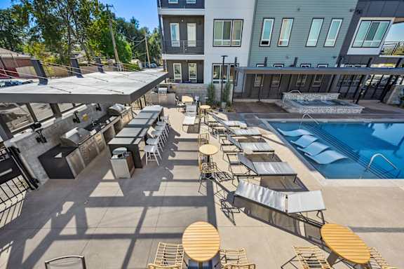 Outdoor pool deck with lounge seating and grilling stations at Sequel Homes Apartments, Englewood, CO