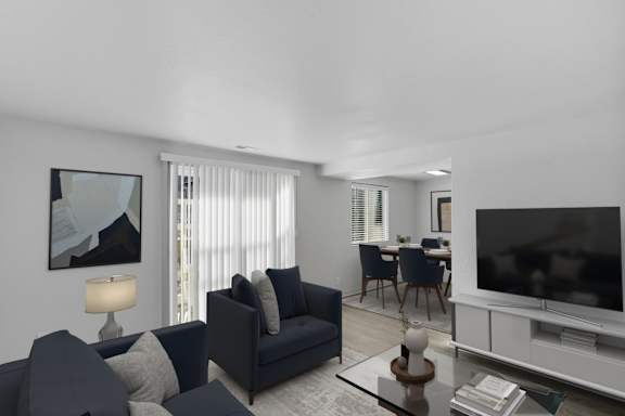 A modern living room with a dark blue sofa and a television. at Park Station Apartments, Midvale, Utah