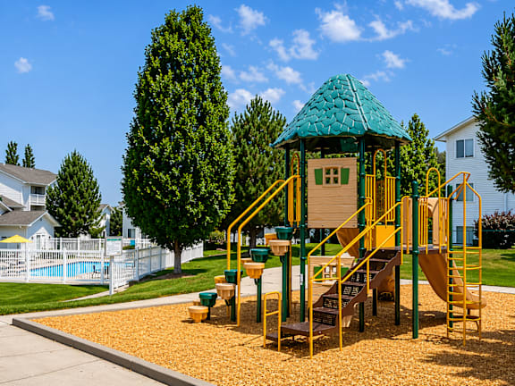 A playground with a green roof and yellow stairs.
