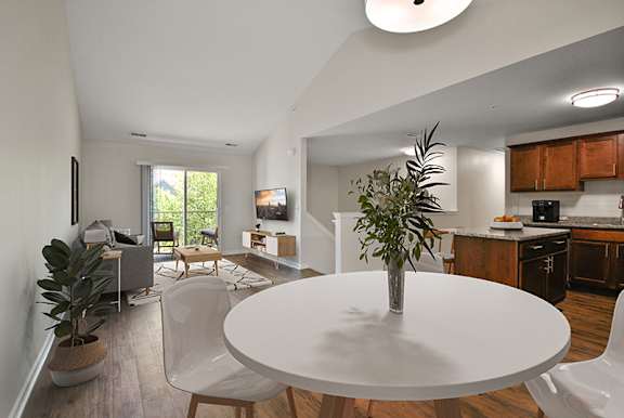 A white table with a plant on it in the middle of a room.