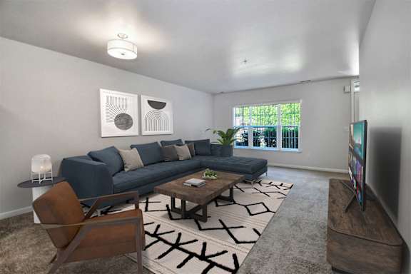 A living room with a blue couch, a coffee table, and a television.