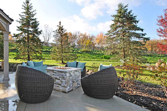 Two chairs and a table are on a patio.