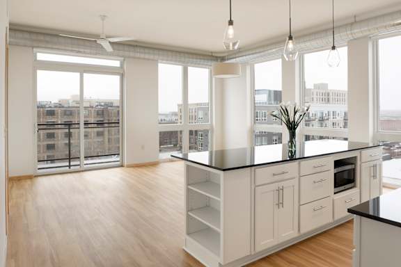 A kitchen with white cabinets and a black countertop.