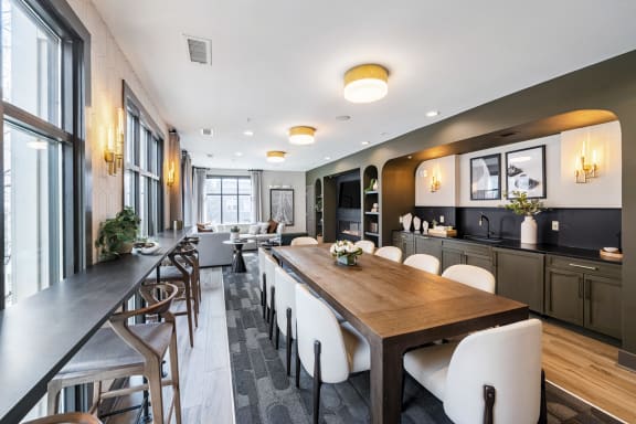 a dining room with a long wooden table and white chairs at Park & Kingston, Charlotte, NC 28203