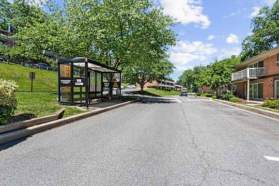 A bus stop with a sign that reads "BUS STOP" is located on the side of a street.