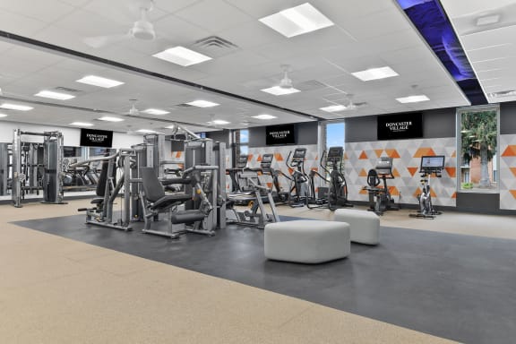a gym with weights and other exercise equipment on the floor at Doncaster Village Apartments, Parkville, 21234