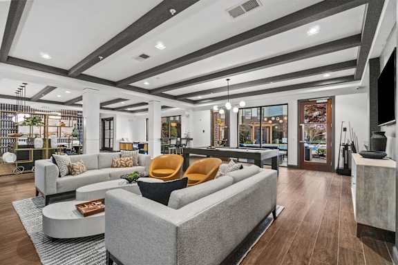 A modern clubroom with a grey sofa and a coffee table. at 1010 Dilworth Apartments, North Carolina, 28204