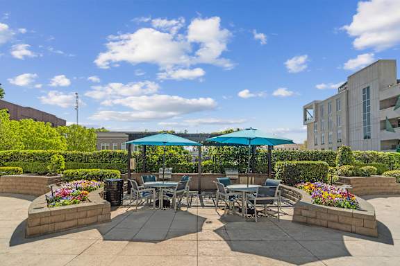 A patio with tables and chairs under umbrellas. at Park and Kingston, Charlotte, NC, 28203