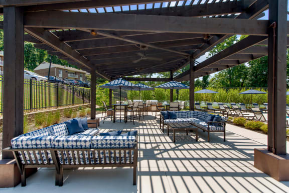 a patio with couches and tables and umbrellas at Padonia Village Apartments, Timonium, MD