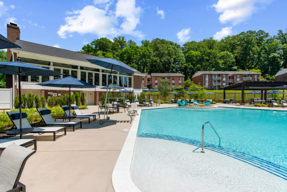resort style swimming pool with apartments and community center in the background at Padonia Village Apartments, Timonium, MD