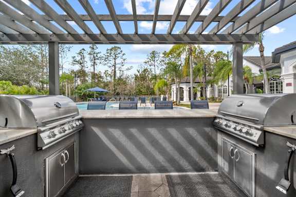 pergola with two grills overlooking pool
