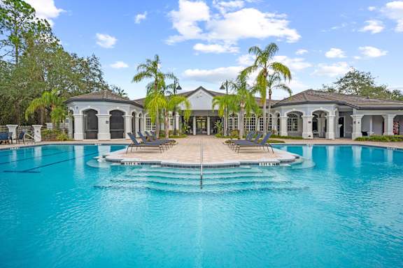 A large swimming pool in front of a house.