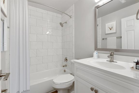 A white bathroom with a toilet, sink, and tub.