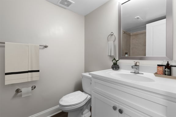 a bathroom with a sink toilet and mirror at Padonia Village Apartments, Timonium MD