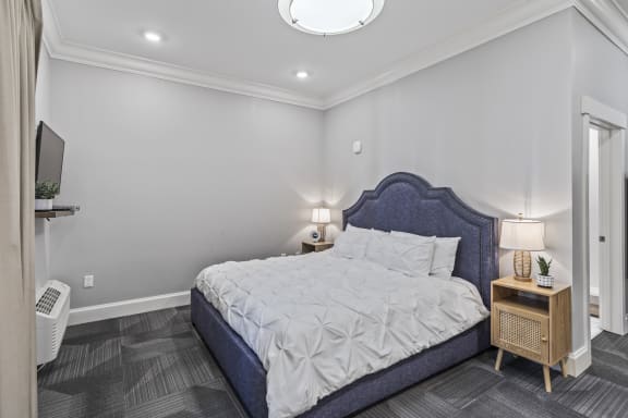 a white bedroom with a blue bed and white walls at Central Island Square, Daniel Island, SC, 29492