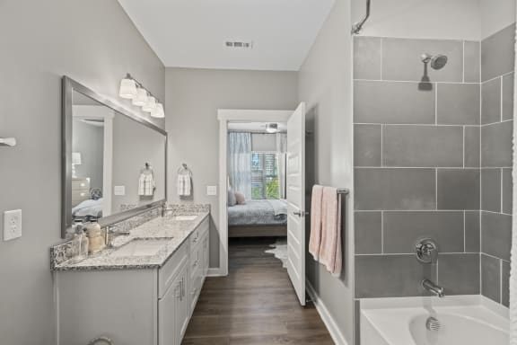 a bathroom with a shower and a sink and a mirror at Central Island Square, Daniel Island, South Carolina