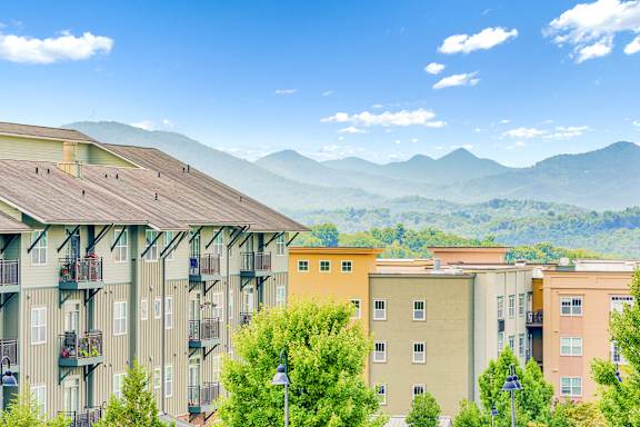 Apartment buildings with balconies overlooking a mountain range at The Lofts at Reynolds Village Apartments, Asheville