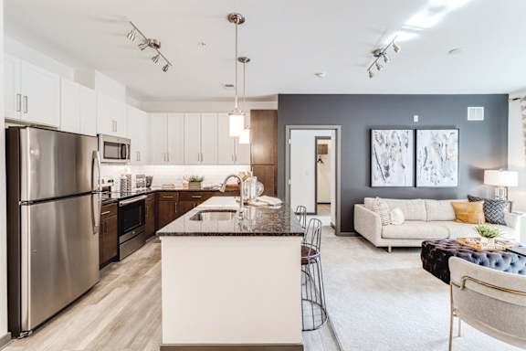 a kitchen and living room with stainless steel appliances  at Dartmoor Place at Oxford Square Apartments, Hanover