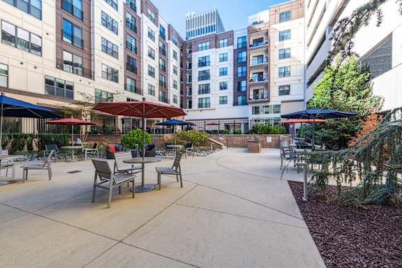 A courtyard with tables and chairs surrounded by buildings.
