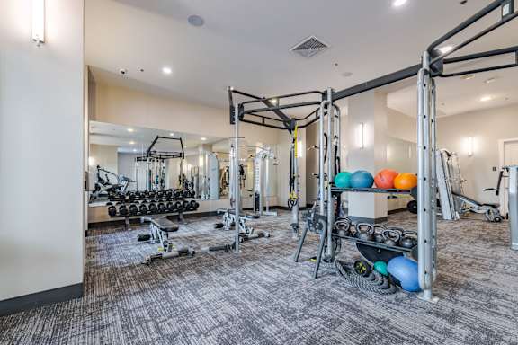 A gym with a variety of equipment including weights and weight machines.