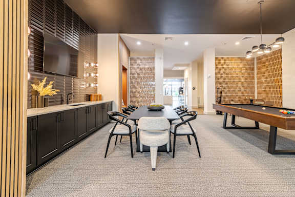 A modern clubhouse room with a table set for four.